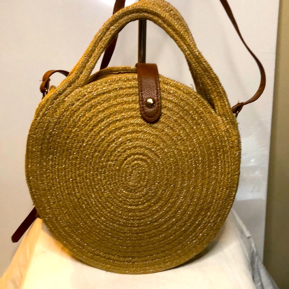 Kichimall straw woven round shaped handbag. Bag has silver glitter on it.